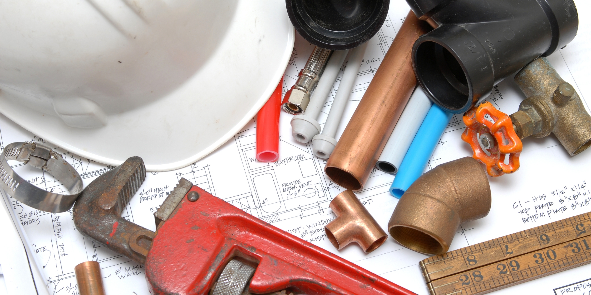 plumbing tools on top of house blueprints